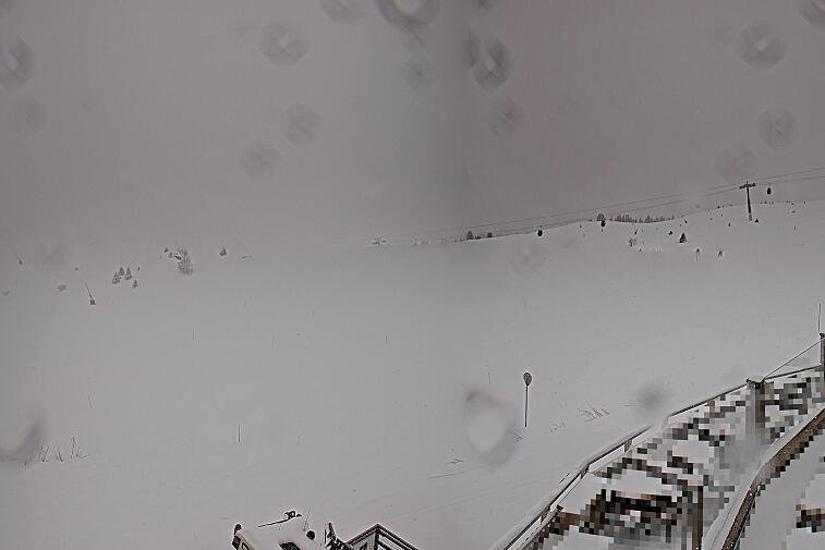 Birds-eye webcam view of conditions on the pistes above Courchevel 1650. The top station of the Ariondaz cable car is visible on the left-hand side of the shot.