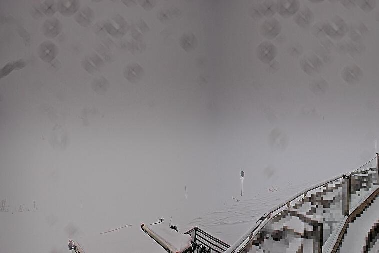 Birds-eye webcam view of conditions on the pistes above Courchevel 1650. The top station of the Ariondaz cable car is visible on the left-hand side of the shot.