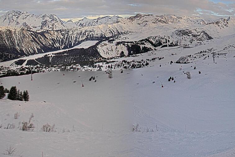 Birds-eye webcam view of conditions on the pistes above Courchevel 1650. The top station of the Ariondaz cable car is visible on the left-hand side of the shot.