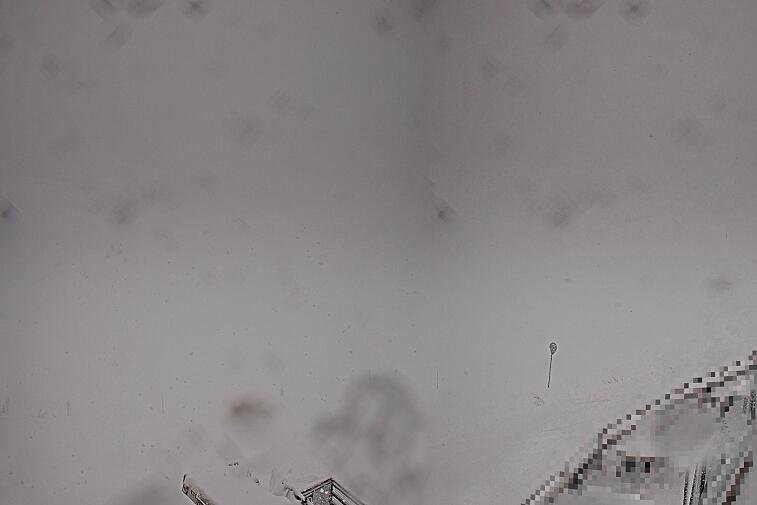 Birds-eye webcam view of conditions on the pistes above Courchevel 1650. The top station of the Ariondaz cable car is visible on the left-hand side of the shot.