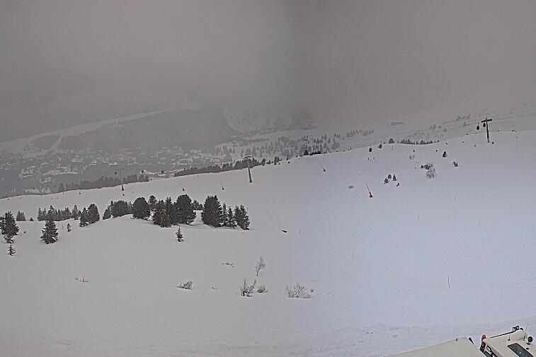 Birds-eye webcam view of conditions on the pistes above Courchevel 1650. The top station of the Ariondaz cable car is visible on the left-hand side of the shot.