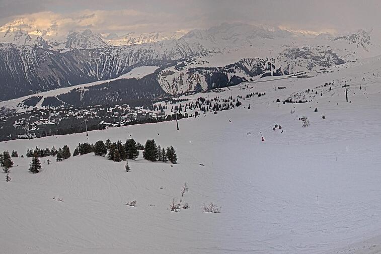 Birds-eye webcam view of conditions on the pistes above Courchevel 1650. The top station of the Ariondaz cable car is visible on the left-hand side of the shot.