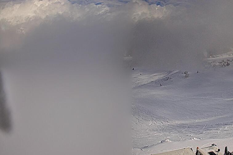 Birds-eye webcam view of conditions on the pistes above Courchevel 1650. The top station of the Ariondaz cable car is visible on the left-hand side of the shot.
