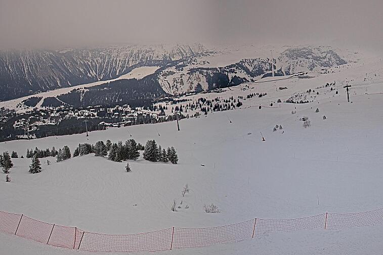 Birds-eye webcam view of conditions on the pistes above Courchevel 1650. The top station of the Ariondaz cable car is visible on the left-hand side of the shot.