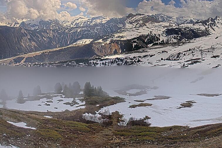 Birds-eye webcam view of conditions on the pistes above Courchevel 1650. The top station of the Ariondaz cable car is visible on the left-hand side of the shot.
