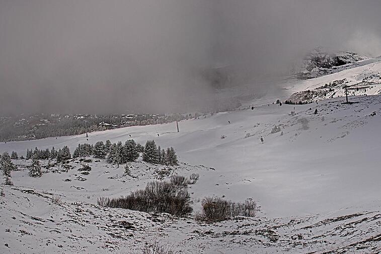 Birds-eye webcam view of conditions on the pistes above Courchevel 1650. The top station of the Ariondaz cable car is visible on the left-hand side of the shot.