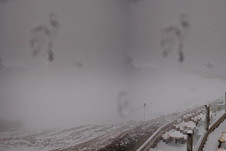 Birds-eye webcam view of conditions on the pistes above Courchevel 1650. The top station of the Ariondaz cable car is visible on the left-hand side of the shot.