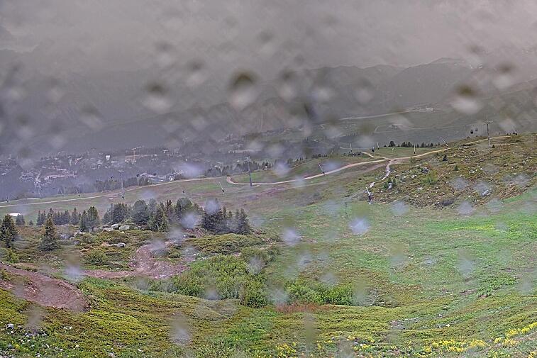Birds-eye webcam view of conditions on the pistes above Courchevel 1650. The top station of the Ariondaz cable car is visible on the left-hand side of the shot.