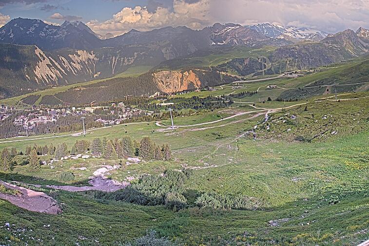 Birds-eye webcam view of conditions on the pistes above Courchevel 1650. The top station of the Ariondaz cable car is visible on the left-hand side of the shot.