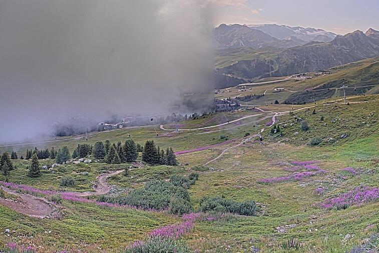 Birds-eye webcam view of conditions on the pistes above Courchevel 1650. The top station of the Ariondaz cable car is visible on the left-hand side of the shot.