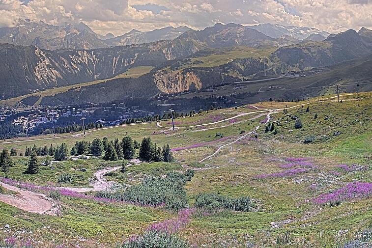 Birds-eye webcam view of conditions on the pistes above Courchevel 1650. The top station of the Ariondaz cable car is visible on the left-hand side of the shot.