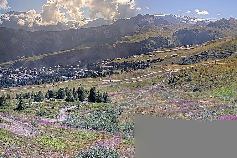 Birds-eye webcam view of conditions on the pistes above Courchevel 1650. The top station of the Ariondaz cable car is visible on the left-hand side of the shot.