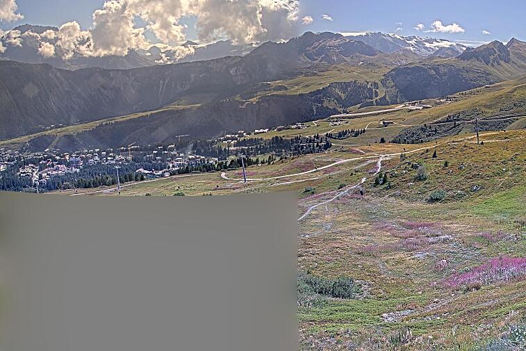Birds-eye webcam view of conditions on the pistes above Courchevel 1650. The top station of the Ariondaz cable car is visible on the left-hand side of the shot.