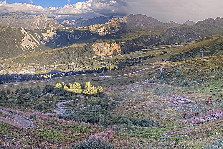 Birds-eye webcam view of conditions on the pistes above Courchevel 1650. The top station of the Ariondaz cable car is visible on the left-hand side of the shot.