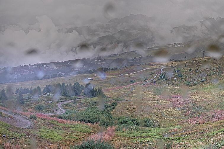 Birds-eye webcam view of conditions on the pistes above Courchevel 1650. The top station of the Ariondaz cable car is visible on the left-hand side of the shot.