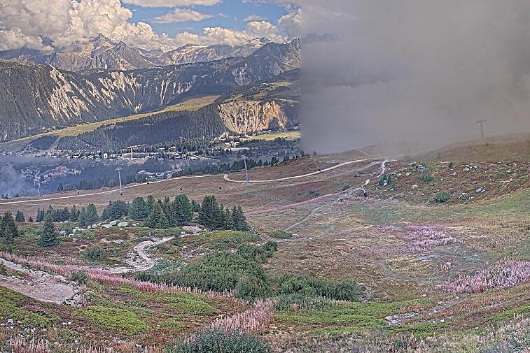 Birds-eye webcam view of conditions on the pistes above Courchevel 1650. The top station of the Ariondaz cable car is visible on the left-hand side of the shot.