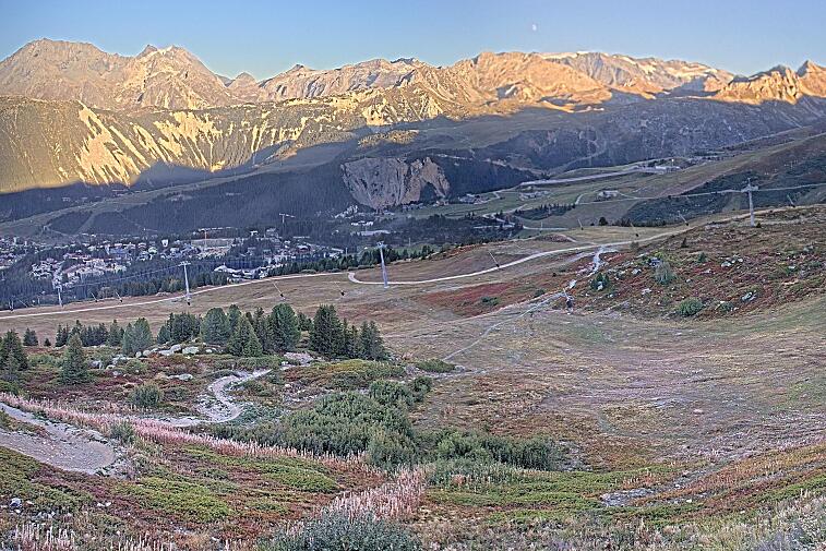 Birds-eye webcam view of conditions on the pistes above Courchevel 1650. The top station of the Ariondaz cable car is visible on the left-hand side of the shot.