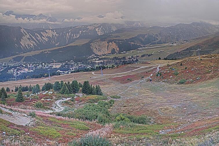 Birds-eye webcam view of conditions on the pistes above Courchevel 1650. The top station of the Ariondaz cable car is visible on the left-hand side of the shot.