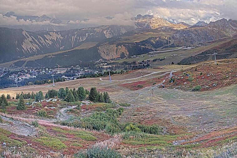 Birds-eye webcam view of conditions on the pistes above Courchevel 1650. The top station of the Ariondaz cable car is visible on the left-hand side of the shot.