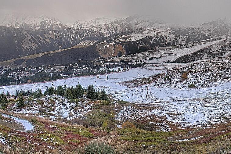 Birds-eye webcam view of conditions on the pistes above Courchevel 1650. The top station of the Ariondaz cable car is visible on the left-hand side of the shot.