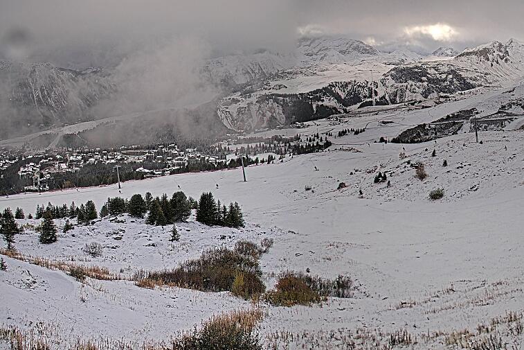 Birds-eye webcam view of conditions on the pistes above Courchevel 1650. The top station of the Ariondaz cable car is visible on the left-hand side of the shot.