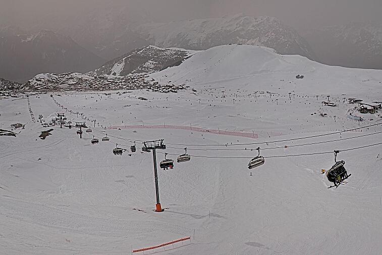 Webcam view of the whole of the Marmottes 2300m ski area and piste-front in the foreground, and the main gondola the Grand Rousses is on the far right along with La Folie Douce restaurant terrace
