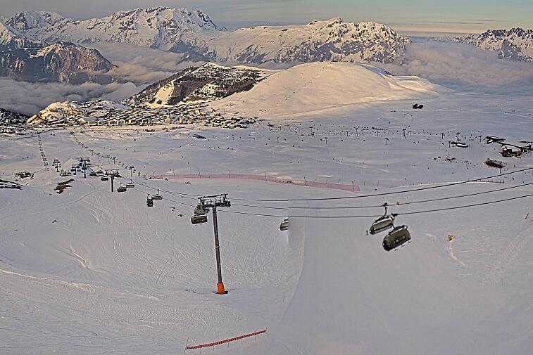 Webcam view of the whole of the Marmottes 2300m ski area and piste-front in the foreground, and the main gondola the Grand Rousses is on the far right along with La Folie Douce restaurant terrace