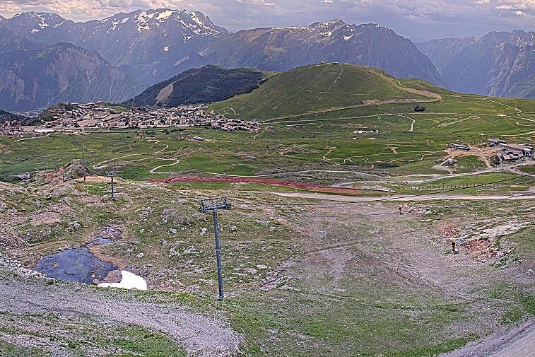 Webcam view of the whole of the Marmottes 2300m ski area and piste-front in the foreground, and the main gondola the Grand Rousses is on the far right along with La Folie Douce restaurant terrace