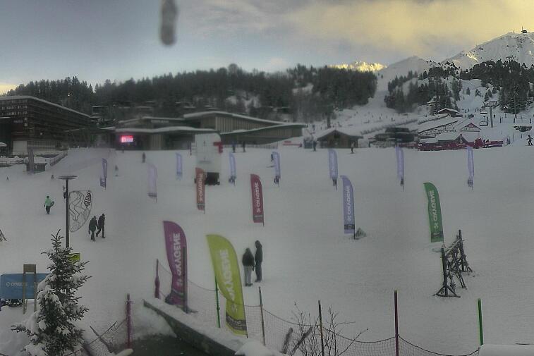 Webcam view across La Plagne centre piste-front. On the left you'll be able to see local ski schools giving lessons. The peak in the middle is La Grande Rochette. On the right is the Stade piste.