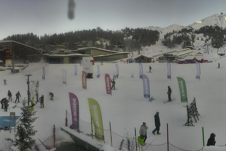 Webcam view across La Plagne centre piste-front. On the left you'll be able to see local ski schools giving lessons. The peak in the middle is La Grande Rochette. On the right is the Stade piste.
