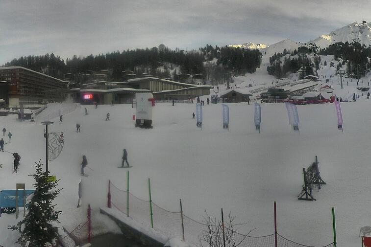 Webcam view across La Plagne centre piste-front. On the left you'll be able to see local ski schools giving lessons. The peak in the middle is La Grande Rochette. On the right is the Stade piste.