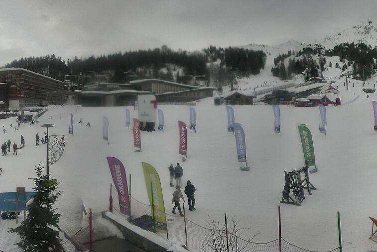 Webcam view across La Plagne centre piste-front. On the left you'll be able to see local ski schools giving lessons. The peak in the middle is La Grande Rochette. On the right is the Stade piste.