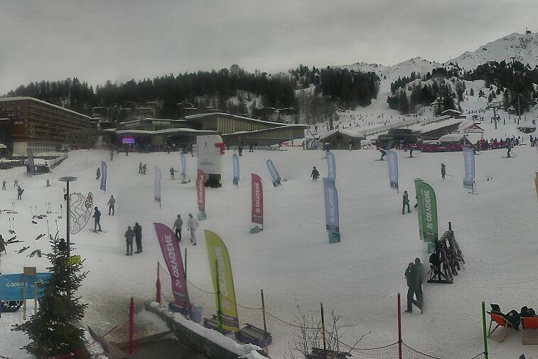 Webcam view across La Plagne centre piste-front. On the left you'll be able to see local ski schools giving lessons. The peak in the middle is La Grande Rochette. On the right is the Stade piste.