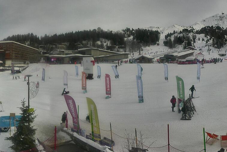 Webcam view across La Plagne centre piste-front. On the left you'll be able to see local ski schools giving lessons. The peak in the middle is La Grande Rochette. On the right is the Stade piste.