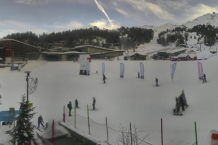 Webcam view across La Plagne centre piste-front. On the left you'll be able to see local ski schools giving lessons. The peak in the middle is La Grande Rochette. On the right is the Stade piste.