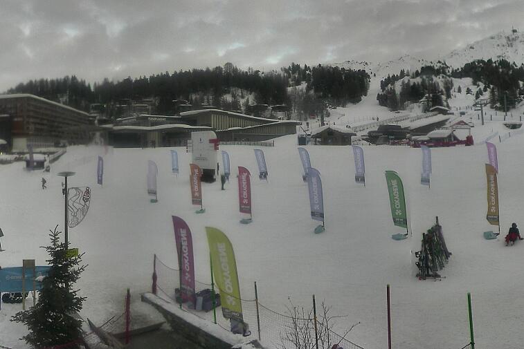 Webcam view across La Plagne centre piste-front. On the left you'll be able to see local ski schools giving lessons. The peak in the middle is La Grande Rochette. On the right is the Stade piste.