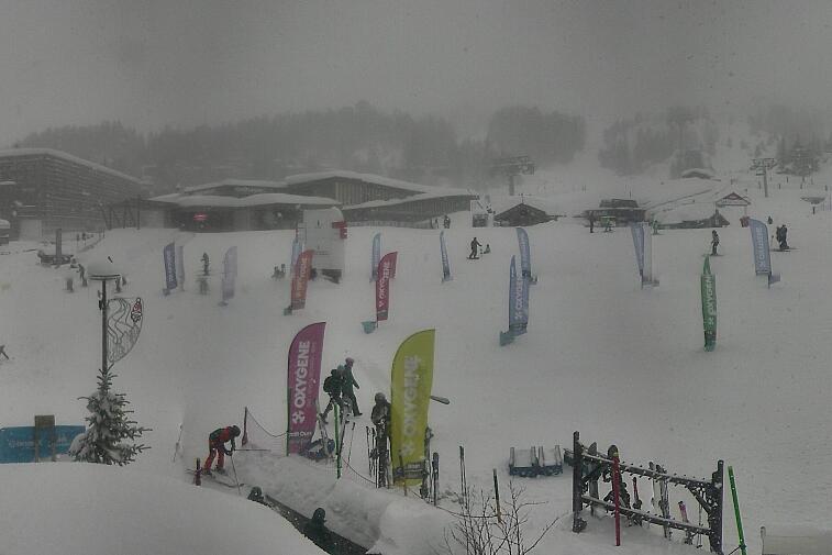 Webcam view across La Plagne centre piste-front. On the left you'll be able to see local ski schools giving lessons. The peak in the middle is La Grande Rochette. On the right is the Stade piste.