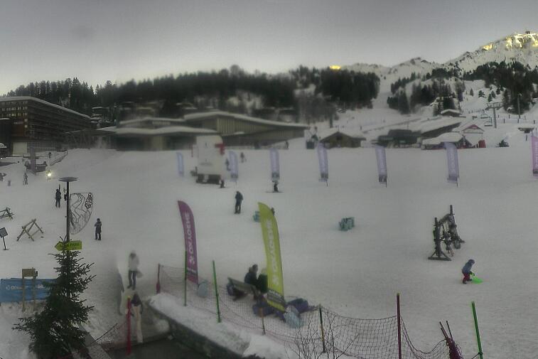 Webcam view across La Plagne centre piste-front. On the left you'll be able to see local ski schools giving lessons. The peak in the middle is La Grande Rochette. On the right is the Stade piste.