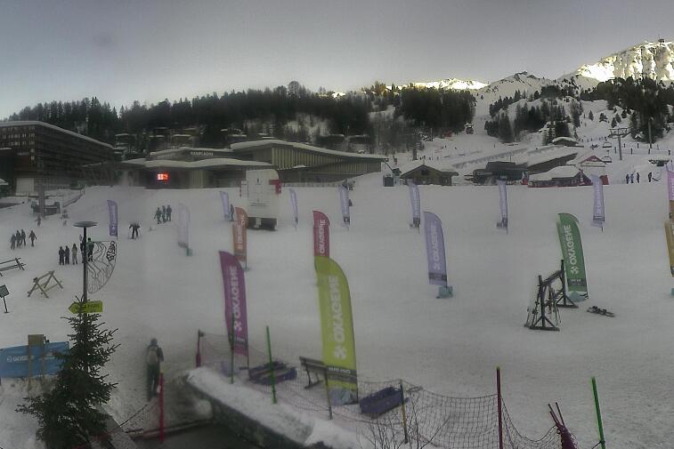 Webcam view across La Plagne centre piste-front. On the left you'll be able to see local ski schools giving lessons. The peak in the middle is La Grande Rochette. On the right is the Stade piste.