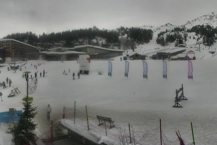 Webcam view across La Plagne centre piste-front. On the left you'll be able to see local ski schools giving lessons. The peak in the middle is La Grande Rochette. On the right is the Stade piste.