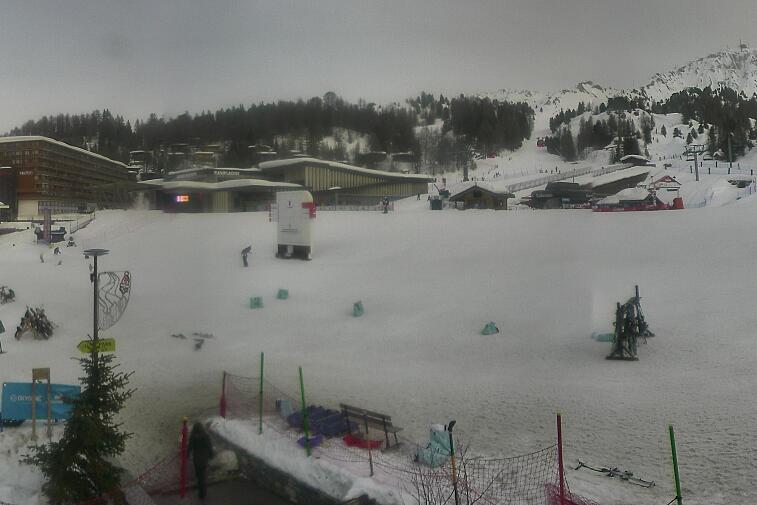 Webcam view across La Plagne centre piste-front. On the left you'll be able to see local ski schools giving lessons. The peak in the middle is La Grande Rochette. On the right is the Stade piste.