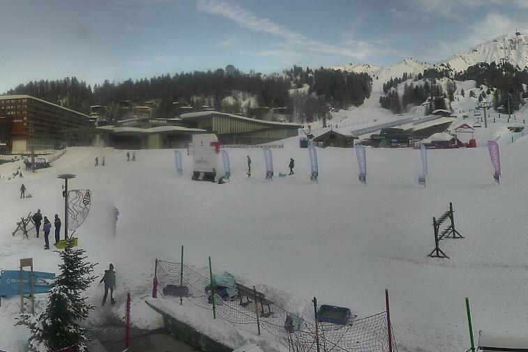 Webcam view across La Plagne centre piste-front. On the left you'll be able to see local ski schools giving lessons. The peak in the middle is La Grande Rochette. On the right is the Stade piste.
