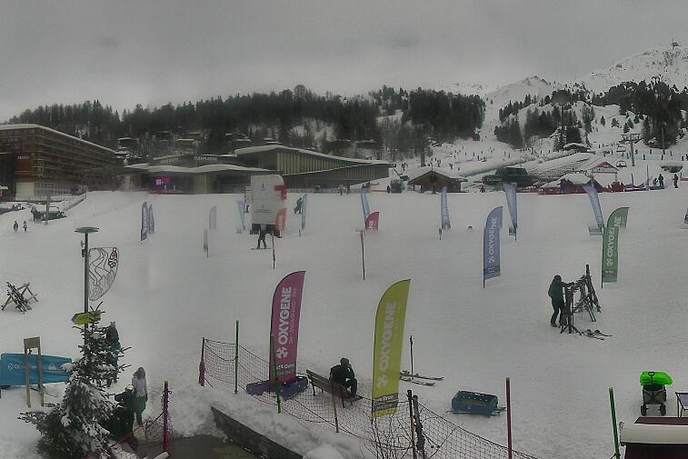 Webcam view across La Plagne centre piste-front. On the left you'll be able to see local ski schools giving lessons. The peak in the middle is La Grande Rochette. On the right is the Stade piste.