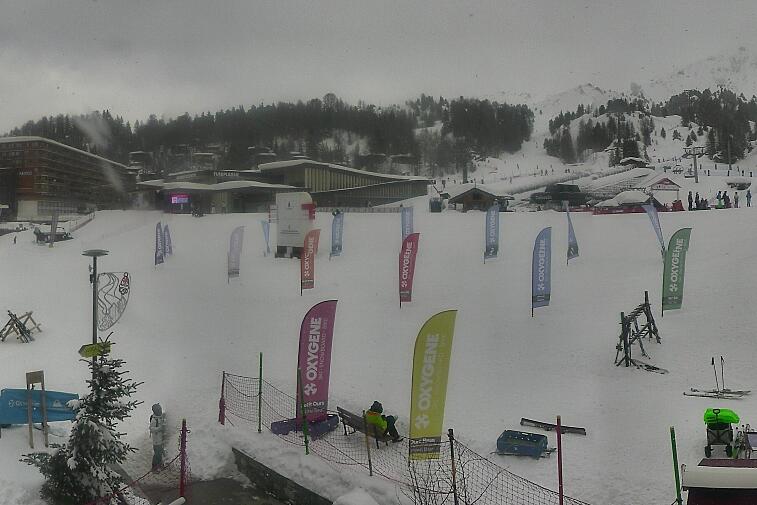 Webcam view across La Plagne centre piste-front. On the left you'll be able to see local ski schools giving lessons. The peak in the middle is La Grande Rochette. On the right is the Stade piste.