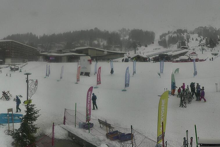 Webcam view across La Plagne centre piste-front. On the left you'll be able to see local ski schools giving lessons. The peak in the middle is La Grande Rochette. On the right is the Stade piste.