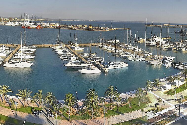 Webcam view of Palma de Mallorca marina, which caters to boats of all shapes and sizes. The cathedral La Seu can be seen in the distance. In the foreground is the Avinguda de Gabriel Roca.