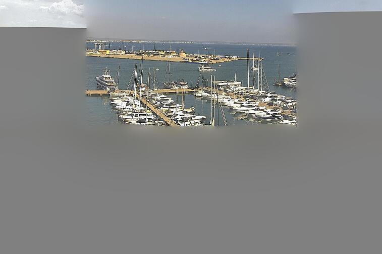 Webcam view of Palma de Mallorca marina, which caters to boats of all shapes and sizes. The cathedral La Seu can be seen in the distance. In the foreground is the Avinguda de Gabriel Roca.