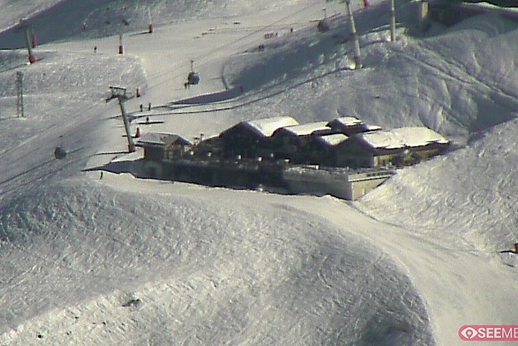 Webcam view of the Folie Douce mountain restaurant in Meribel.  In the background are the Biche (blue) and Maudit (red) pistes; and the pictured lift/mid-station is the Saulire Express.