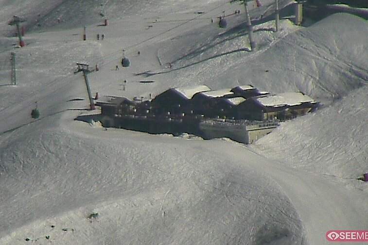 Webcam view of the Folie Douce mountain restaurant in Meribel.  In the background are the Biche (blue) and Maudit (red) pistes; and the pictured lift/mid-station is the Saulire Express.