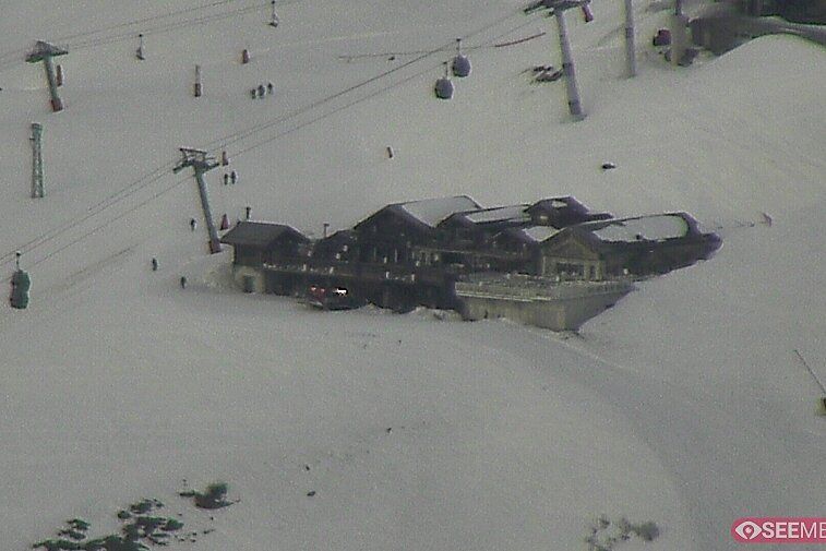 Webcam view of the Folie Douce mountain restaurant in Meribel.  In the background are the Biche (blue) and Maudit (red) pistes; and the pictured lift/mid-station is the Saulire Express.